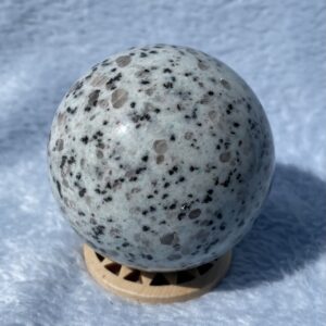 Kiwi jasper sphere on soft blue surface